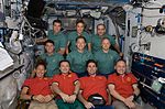 STS-126 besättning klädd i grön tröga och Expedition 18 i röd, efter presskonferensen den 21 november.