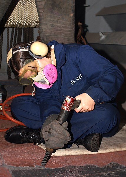 File:US Navy 041118-N-1125B-001 Seaman Heather Berry of Lansing, Mich., prepares the metal deck in a fueling station for resurfacing, using a needle gun to remove old paint and non-skid material aboard USS George Washington (CVN 73).jpg