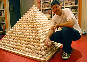 Zack Hample posing with a pyramid of baseballs.jpg
