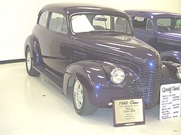 '40 Chev custom with painted grille, small front turnsignals, custom doo r mirror, and frenched radio aerial. Note non-stock one-piece windshield.