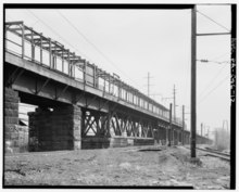 The abandoned 52nd Street station in 1999 APPROACH TRESTLE, SHOWING TRUSS OVER 52nd STREET AND PASSENGER PLATFORMS, LOOKING EAST. - Pennsylvania Railroad, 52nd Street Bridge, North Fifty-second Street at Lancaster HAER PA,51-PHILA,722-12.tif