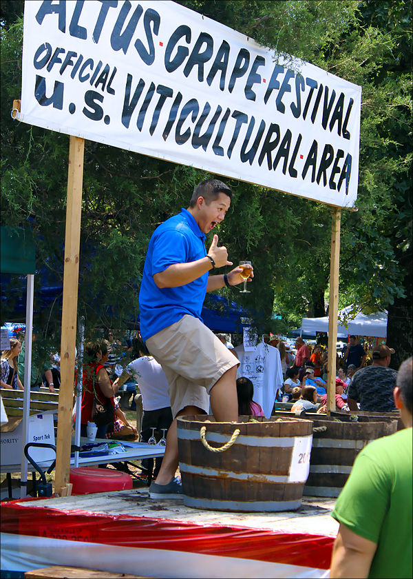 A festival attendee participates in traditional grape stomping at the 2013 Altus Grape Festival
