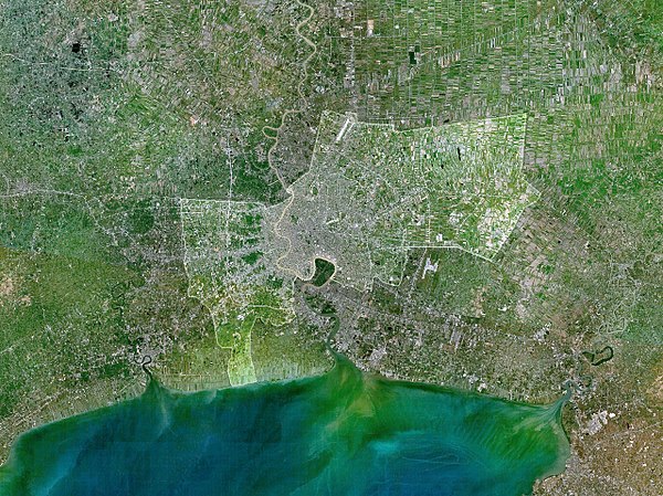 The city of Bangkok is highlighted in this satellite image of the lower Chao Phraya delta. The built-up urban area extends northward and southward int