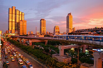Sonsopgang in Bangkok, Thailand, met die Skytrain en die moderne uitsig, soos gesien vanaf die hoek van Thanon Silom.