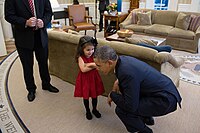 Barack Obama bends down to listen to the daughter of a departing U.S. Secret Service agent, 2013