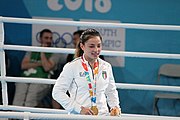 Deutsch: Boxen bei den Olympischen Jugendspielen 2018 Tag 12, 18. Oktober 2018 - Medaillenzeremonie im Fliegengewicht der Mädchen - Gold: Martina La Piana (Italien), Silber: Adijat Gbadamosi (Nigeria), Bronze: Heaven Destiny Garcia (USA); Medaillenübergabe durch Habu Gumel (IOC, Nigeria), Geschenkübergabe durch Dr. Joseph O. Ayeni (Nigeria, AIBA). English: Boxing at the 2018 Summer Youth Olympics on 18 October 2018 – Girl's flyweight Medal Ceremony - Gold: Martina La Piana (Italy), Silver: Adijat Gbadamosi (Nigeria), Bronze: Heaven Destiny Garcia (USA); Medal handover by Habu Gumel (IOC, Nigeria), Gift presented by Dr. Joseph O. Ayeni (Nigeria, AIBA). Español: Boxeo en los Juegos Olímpicos Juveniles de Verano de 2018 en 18 de octubre de 2018 - Ceremonia de la Medalla de peso mosca para niñas - Oro: Martina La Piana (Italia), Plata: Adijat Gbadamosi (Nigeria), Bronce: Heaven Destiny Garcia (Estados Unidos); Entrega de medallas por Habu Gumel (COI, Nigeria), Regalo presentado por Joseph O. Ayeni (Nigeria, AIBA).