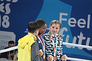 Deutsch: Boxen bei den Olympischen Jugendspielen 2018 Tag 12, 18. Oktober 2018 - Medaillenzeremonie im Leichtgewicht der Mädchen - Gold: Caroline Sara DuBois (Großbritannien), Silber: Porntip Buapa (Thailand), Bronze: Oriana Saputo (Argentinien); Medaillenübergabe durch Habu Gumel (IOC, Nigeria), Geschenkübergabe durch Raymond Silvas (USA, AIBA). English: Boxing at the 2018 Summer Youth Olympics on 18 October 2018 – Girl's Lightweight Medal Ceremony - Gold: Caroline Sara DuBois (Great Britain), Silver: Porntip Buapa (Thailand), Bronze: Oriana Saputo (Argentina); Medal handover by Habu Gumel (IOC, Nigeria), Gift presented by Raymond Silvas (USA, AIBA). Español: Boxeo en los Juegos Olímpicos Juveniles de Verano de 2018 en 18 de octubre de 2018 - Ceremonia de la Medalla de peso ligero para niñas - Oro: Caroline Sara DuBois (Gran Bretaña), Plata: Porntip Buapa (Thailand), Bronce: Oriana Saputo (Argentina); Entrega de medallas por Habu Gumel (COI, Nigeria), Regalo presentado por Raymond Silvas (EE. UU., AIBA).