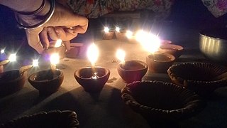 Women placing a Diwali Diya on the occasion of Indian festival of Light, Diwali