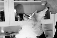 A person performing a vape trick.