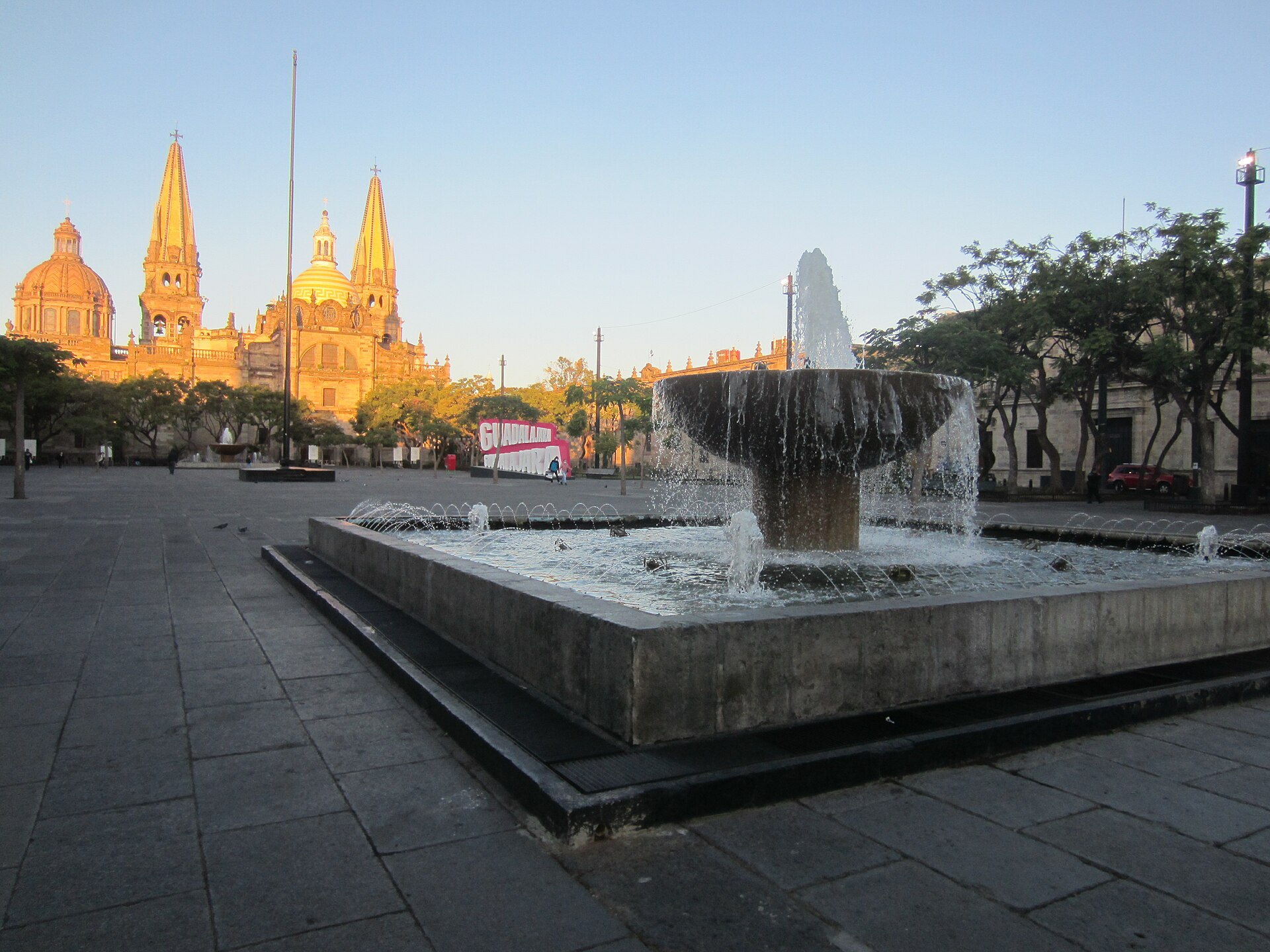 The plaza in 2021; one of the square's fountains is in the foreground and Guadalajara Cathedral is in the background