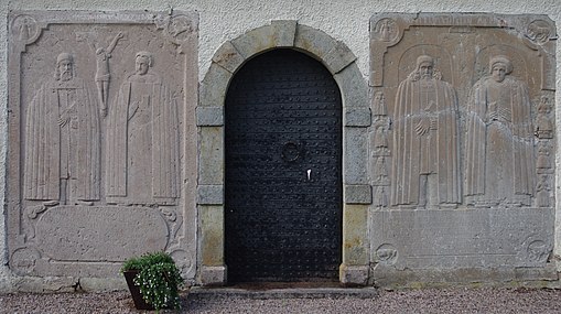 Porträttgravstenar från 1600-talet på vapenhusets fasad. Den högra stenen är över kyrkoherden Petrus (Peder) Rangelius, död 1697, och hans maka Anna Larsdotter Welt. Den vänstra är över Haquinus Torstani Roth d. 1654 o.h.h. Ingeborg Månsdotter 1602-1671.[3]