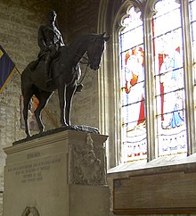 Both the statue (left) and the associated wooden memorial board (lower right) were moved from the family chapel to the west end of the church's north aisle He hath out outsoared the shadow of our night (geograph 4054892) (cropped).jpg