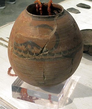 A clay pot with an animal with horns painted