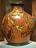 A large jar by Wilmot decorated with pictures of a bird and flowers, sitting on a table