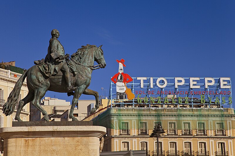 File:Madrid. Puerta del Sol square. Equestrian statue of Carlos III. Tío Pepe neon sign. Spain (4078215594).jpg