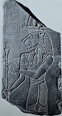 The fragment, discovered in the lion temple at Meroë, capital of the Meroitic Kingdom, was part of a commemorative monument to King Tanyidamani. One side depicts the ruler in royal costume with ram's-head earrings, an Egyptian crown, and a scepter in his hand. An image of the lion-headed war- and fertility-god Apedemak appears on the other side. The deity holds a bundle of sorghum and a scepter topped with a small seated lion. The inscriptions are in Meroitic script and name the king and the god.