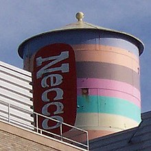 The New England Confectionery Co. water tower, built 1927, was painted in 1996 to resemble a roll of Necco Wafers, but repainted to a new design in 2004 by Novartis. Necco factory water tower.jpg