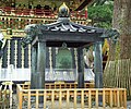 Bronze bell. Behind it is the bell tower.