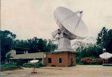 The Leighton-style telescope at the Raman Research Institute. The grey building to the left housed the telescope's control room. Raman Research Institute Leighton Telescope.png