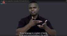 Screenshot of Razaq Fakir making International Sign translation. There is a subtitle that reads: Every language is a system of being, doing and communicating in the world