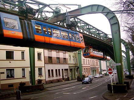 Two Wuppertal Schwebebahn trains meet above the street