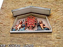 The sculpture of cherubs aside the coat of arms of Gloucester at the entrance to Three Cocks Lane, off Westgate Street. The sculpture originally adorned the pediment of the former Booth's Hall. Sculpture of cherubs in Three Cocks Lane - geograph.org.uk - 1432413.jpg