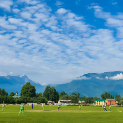 "Captivating scene of youth engaged in a spirited game of cricket amidst the majestic backdrop of the Himalayan mountains at Shallabugh Playground"(Photo by Dar Sajad)