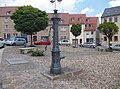 Pavement of the market square and manual pump in front of the town hall