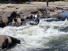 A whitewater kayaker running a class II+ rapid on the James River in Richmond, Virginia Whitewater kayaker classIV.jpg