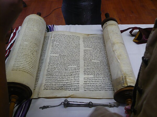 A Torah scroll and silver pointer (yad) used in reading.