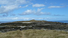 L'île, son cairn et le passage rocheux offrant l'accès à marée basse.