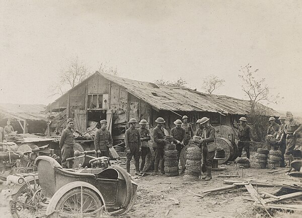 Doughboys of the 302nd Field Signal Battalion, 77th Division, unrolling and rewinding telephone wire into smaller rolls for convenience in field work,