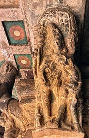 Artwork shows a collapsing sorrowful woman being helped. 6th century Vishnu lifting a collapsing woman on pillar top looking below in Cave 3, Badami Hindu cave temple Karnataka 1.jpg