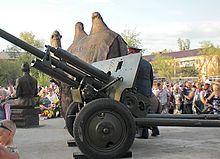Fotografia de uma estátua em tamanho real de um camelo com um canhão.