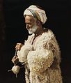 A man from Ramallah spinning wool. Hand tinted photograph from 1919, restored (American Colony Collection)