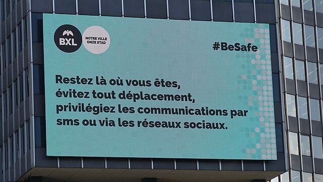 Digital billboard in Brussels. It reads, in French, "Stay where you are, avoid all movement, prioritise communications by text message or social media