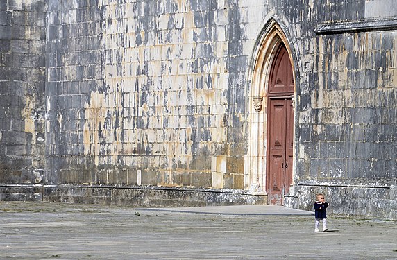 Child walking alone in front of Batalha Monastery, Portugal