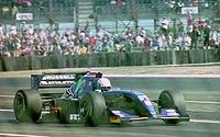 David Brabham driving for the new team Simtek during the British GP David Brabham - Simtek S941 leaves the pits at the 1994 British Grand Prix (32388881792).jpg