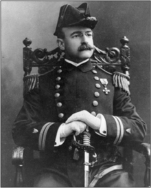 Kapitán Francis Saltus Van Boskerck představuje v uniformě, sedí a drží meč mezi nohama