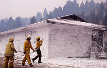 Firefighters spray fight fighting foam on a building at Mammoth Hot Springs on August 10, 1988