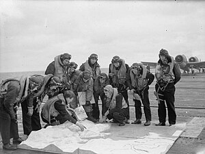 Hellcat pilots assigned to 800 Naval Air Squadron studying a model of Tirpitz's anchorage ahead of the Operation Tungsten attack Hellcat pilots of the escort carrier HMS Emperor studying a model of the German battleship TIRPITZ and AltenFjord.jpg