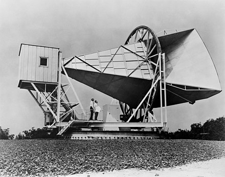 Penzias and Wilson stand at the 15 meter Holmdel Horn Antenna that brought their most notable discovery.