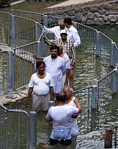 Men lined up to be baptized by immersion in the River Jordan Jordan river baptism cue.jpg