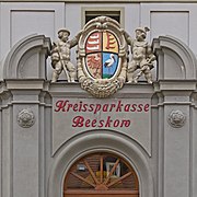 Wappen des Landkreises Beeskow-Storkow (1836–1950) über dem Portal des Gebäudes der Kreissparkasse