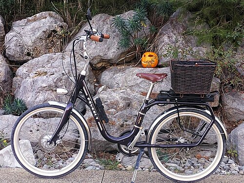 vélo devant des rochers sur lesquels une citrouille d'Halloween est posée