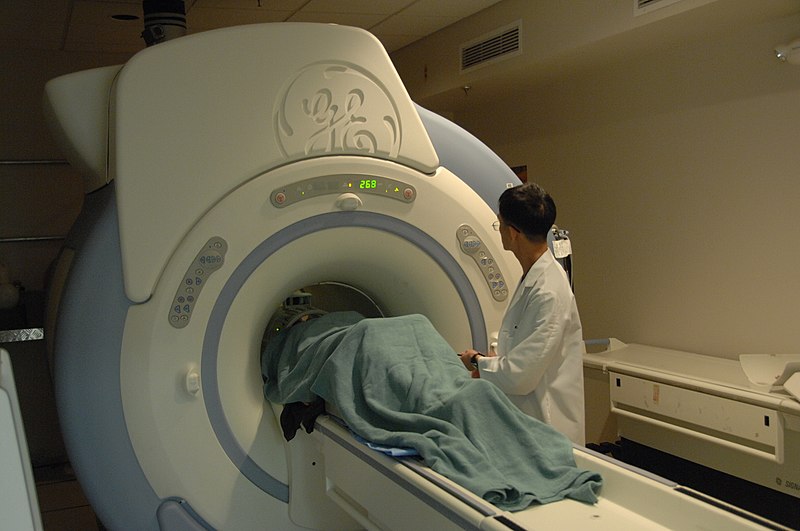 File:MRI machine with patient (23423505123).jpg