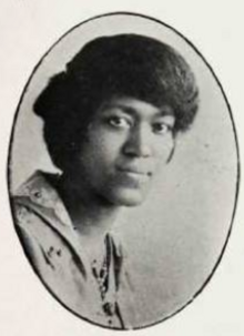 A young Black woman, wearing a collared jacket, in an oval frame