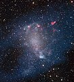 Überlagerte Aufnahmen • des Very Large Array, blau wiedergegeben: neutraler Wasserstoff, • des Atacama Large Millimeter/submillimeter Array, orange: CO • und des MPG/ESO-2,2-m-Teleskops, die die Galaxie­struktur zeigen