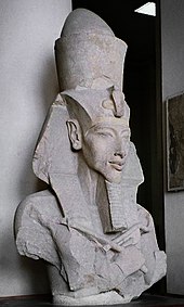Buste monumental en pierre figurant le visage du pharaon surmonté d'une coiffe.