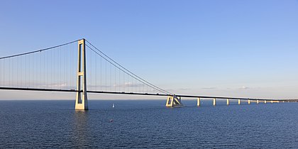 Ponte do Grande Belt (Ponte Leste), Dinamarca, ao entardecer. É uma conexão combinada de ponte e túnel destinada ao tráfego de trem e automóvel que cruza o Grande Belt e conecta Fiónia e Zelândia. A ferrovia foi inaugurada em 1 de junho de 1997 e a ligação rodoviária em 14 de junho de 1998. A ligação tem cerca de 17 km de extensão. Consiste em três pontes separadas, um túnel e um trecho de estrada em Sprogø. A conexão consiste em uma rodovia de 4 pistas e uma ferrovia de via dupla com linhas aéreas elétricas. (definição 5 661 × 2 835)